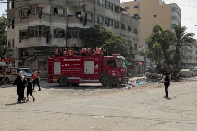 Gaza City Mass Funeral August 3 2026 Palestinian civil defense workers ride on a fire truck ahead of a mass funeral procession in the Al-Sabra neighborhood of Gaza City, Gaza Strip, on August 4, 2026. The remains of 112 members of the Abu Sharia and Al-Hasayneh families were recovered from the rubble of their home following an Israeli strike. Relatives stated the attack claimed the lives of more than 300 people. The bodies were buried at Al-Maamadani Cemetery as military operations continue across the territory. Gaza Gaza Strip Palestinian Territories Copyright: xEyadxAzamx