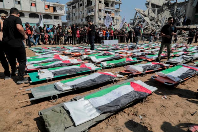 Gaza City Mass Funeral August 3 2026 Mourners gather near rows of bodies wrapped in Palestinian flags during a mass funeral procession in the Al-Sabra neighborhood of Gaza City, Gaza Strip, on August 4, 2026. The remains of 112 members of the Abu Sharia and Al-Hasayneh families were recovered from the rubble of their home following an Israeli strike. Relatives stated the attack claimed the lives of more than 300 people. The bodies were buried at Al-Maamadani Cemetery as military operations continue across the territory. Gaza Gaza Strip Palestinian Territories Copyright: xEyadxAzamx