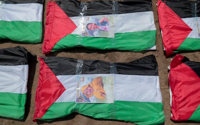 Gaza City Mass Funeral August 3 2026 Photographs rest on bodies wrapped in Palestinian flags during a mass funeral in Gaza City, Gaza Strip, on August 4, 2026. The remains of 112 members of the Abu Sharia and Al-Hasayneh families were recovered from the rubble of their home following an Israeli strike. Relatives stated the attack claimed the lives of more than 300 people. The bodies were buried at Al-Maamadani Cemetery as military operations continue across the territory. Gaza Gaza Strip Palestinian Territories Copyright: xEyadxAzamx