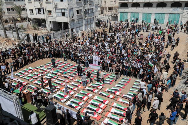Gaza City Mass Funeral August 3 2026 Mourners gather around rows of bodies wrapped in Palestinian flags during a mass funeral procession in the Al-Sabra neighborhood of Gaza City, Gaza Strip, on August 4, 2026. The remains of 112 members of the Abu Sharia and Al-Hasayneh families were recovered from the rubble of their home following an Israeli strike. Relatives stated the attack claimed the lives of more than 300 people. The bodies were buried at Al-Maamadani Cemetery as military operations continue across the territory. Gaza Gaza Strip Palestinian Territories Copyright: xEyadxAzamx