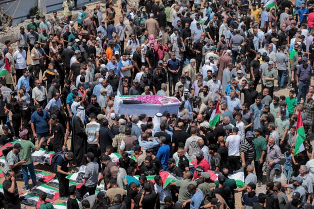 Gaza City Mass Funeral August 3 2026 Mourners carry a flower-covered coffin and other bodies wrapped in Palestinian flags through a street during a mass funeral procession in the Al-Sabra neighborhood of Gaza City, Gaza Strip, on August 4, 2026. The remains of 112 members of the Abu Sharia and Al-Hasayneh families were recovered from the rubble of their home following an Israeli strike. Relatives stated the attack claimed the lives of more than 300 people. The bodies were buried at Al-Maamadani Cemetery as military operations continue across the territory. Gaza Gaza Strip Palestinian Territories Copyright: xEyadxAzamx