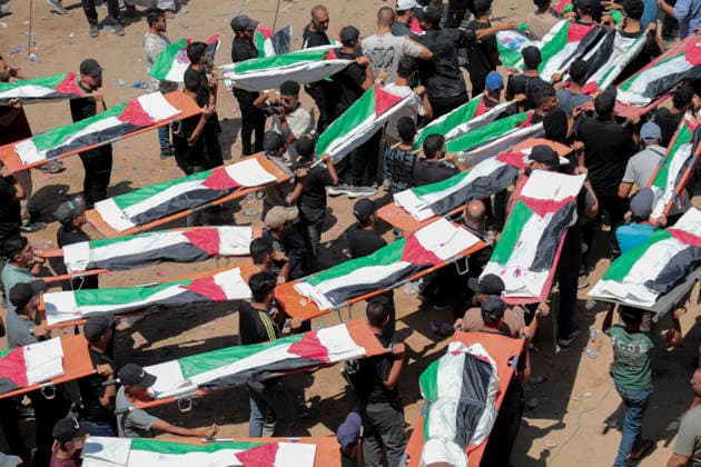 Gaza City Mass Funeral August 3 2026 Mourners carry bodies wrapped in Palestinian flags during a mass funeral procession in the Al-Sabra neighborhood of Gaza City, Gaza Strip, on August 4, 2026. The remains of 112 members of the Abu Sharia and Al-Hasayneh families were recovered from the rubble of their home following an Israeli strike. Relatives stated the attack claimed the lives of more than 300 people. The bodies were buried at Al-Maamadani Cemetery as military operations continue across the territory. Gaza Gaza Strip Palestinian Territories Copyright: xEyadxAzamx