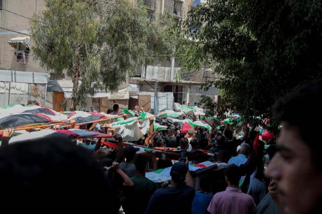 Gaza City Mass Funeral August 3 2026 Mourners carry bodies wrapped in Palestinian flags on stretchers during a mass funeral procession in the Al-Sabra neighborhood of Gaza City, Gaza Strip, on August 4, 2026. The remains of 112 members of the Abu Sharia and Al-Hasayneh families were recovered from the rubble of their home following an Israeli strike. Relatives stated the attack claimed the lives of more than 300 people. The bodies were buried at Al-Maamadani Cemetery as military operations continue across the territory. Gaza Gaza Strip Palestinian Territories Copyright: xEyadxAzamx