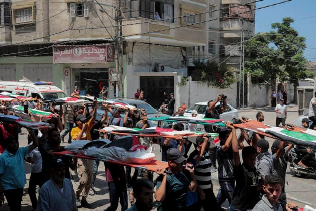 Gaza City Mass Funeral August 3 2026 Mourners carry bodies wrapped in Palestinian flags on stretchers during a mass funeral procession in the Al-Sabra neighborhood of Gaza City, Gaza Strip, on August 4, 2026. The remains of 112 members of the Abu Sharia and Al-Hasayneh families were recovered from the rubble of their home following an Israeli strike. Relatives stated the attack claimed the lives of more than 300 people. The bodies were buried at Al-Maamadani Cemetery as military operations continue across the territory. Gaza Gaza Strip Palestinian Territories Copyright: xEyadxAzamx