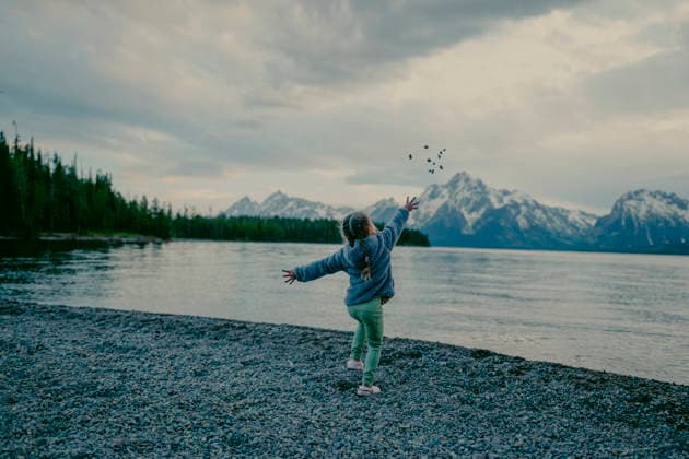Young child throwing rocks into a mountain lake. Jackson, Wyoming, United States CR_TYRI26071521-2078199-01 ,model released, Symbolfoto ,property released