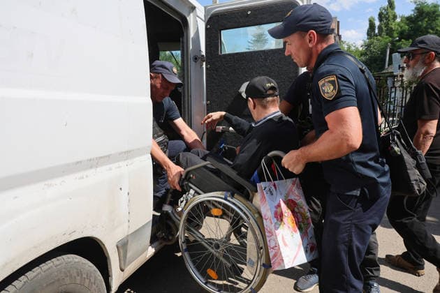 Rescuers assist an elderly man in a wheelchair at an evacuation hub in Kharkiv, Ukraine, August 4, 2026. Evacuation efforts have been intensified in the Kharkiv region, mainly in the Shevchenkove and Staryi Saltiv settlement communities, due to constant Russian bombardment of civilians. (Photo by Viacheslav Madiievskyi Ukrinform) Evacuation hub in Kharkiv  Copyright: xViacheslavxMadiievskyix