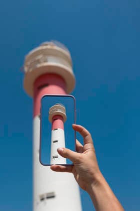 Person taking a photo of a lighthouse with phone Tarragona, Catalonia, Spain R_AULNOK260803-2094934-01 ,model released, Symbolfoto ,property released