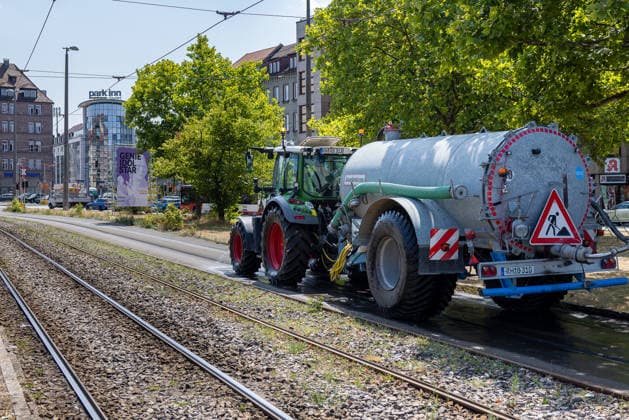 Extremwetter und Hitzewelle in Nürnberg, 05.08.2026 Ein Traktor mit Tankanhänger kühlt bei extremer Hitze die Straßenbahnschienen mit Wasser, um ein Ablösen des Bitumens zu verhindern und den Straßenbahnbetrieb aufrechtzuerhalten. Die Maßnahme soll ein Wiederholen der Schäden aus der vorangegangenen Hitzewelle vermeiden. Nürnberg Bayern Deutschland *** Extreme Weather and Heat Wave in Nuremberg, August 5, 2026 A tractor with a tank trailer is cooling the tram tracks with water amid extreme heat, to prevent the bitumen from peeling off and to keep tram service running. The measure is intended to prevent a recurrence of the damage caused by the previous heat wave. Nuremberg, Bavaria, Germany 20260805-286A4233-M4000