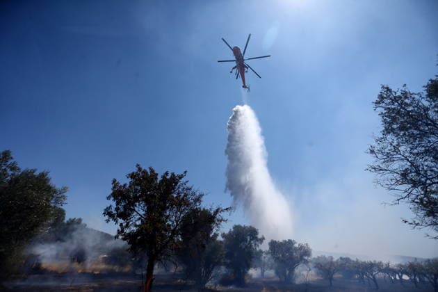 August 5, 2026, Koropi, Greece: Firefighters battle a wildfire in the Koropi area, southeast of Athens, as helicopters carry out repeated water drops to contain the flames. Ground crews worked alongside aerial firefighting units to prevent the fire from spreading amid dry conditions and strong winds. Koropi Greece - ZUMAv62_ 20260805_zaf_v62_016 Copyright: xAristidisxVafeiadakisx