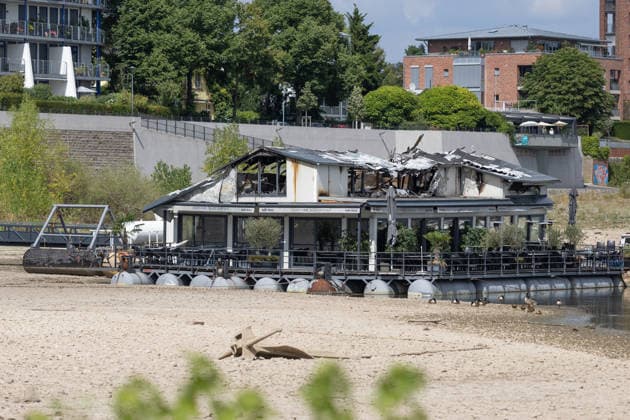 Sürther Bootshaus in Köln einen Tag nach dem Großbrand Ein Tag nach dem Großbrand: Das Sürther Bootshaus in Köln-Sürth, ein beliebtes Ausflugslokal und Restaurant direkt am Rhein, liegt in Trümmern bei dem Feuer am 04.08.2026 brannte vor allem der Dachbereich vollständig aus. Rund 100 Einsatzkräfte der Feuerwehr waren im Großeinsatz, verletzt wurde niemand, die Brandursache ist weiterhin unklar. Köln Sürth Nordrhein-Westfalen Deutschland *** The Sürth Boathouse in Cologne, One Day After the Major Fire One day after the major fire, the Sürth Boathouse in Cologne-Sürth, a popular destination for day trips and a restaurant right on the Rhine, lies in ruins following the fire on August 4, 2026. The roof area, in particular, bur Copyright: xMarcxJohnx