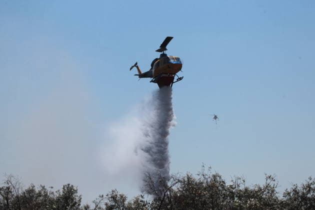 August 5, 2026, Koropi, Greece: Firefighters battle a wildfire in the Koropi area, southeast of Athens, as helicopters carry out repeated water drops to contain the flames. Ground crews worked alongside aerial firefighting units to prevent the fire from spreading amid dry conditions and strong winds. Koropi Greece  - ZUMAv62_ 20260805_zaf_v62_068 Copyright: xAristidisxVafeiadakisx