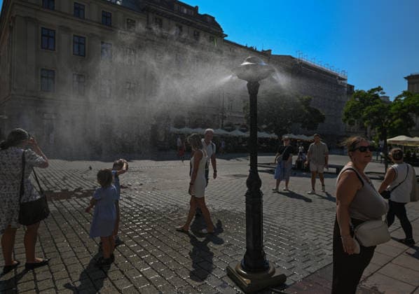 Krakow Hits 39Â°C As Severe Heatwave Triggers Red Weather Alerts Across Poland KRAKOW, POLAND - AUGUST 5: Pedestrians and children seek relief from a municipal water misting installation in the Main Market Square during an intense heatwave on August 5, 2026, in Krakow, Poland. Poland™s Institute of Meteorology and Water Management (IMGW) issued a critical, third-degree red alert for the region as temperatures soared up to 39Â°C (102.2Â°F), prompting local authorities to deploy cooling stations across the city center. Krakow Poland  Copyright: xArturxWidakx originalFilename: widak-krakowhi260805_npqCS.jpg