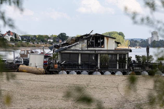 Sürther Bootshaus in Köln einen Tag nach dem Großbrand Ein Tag nach dem Großbrand: Das Sürther Bootshaus in Köln-Sürth, ein beliebtes Ausflugslokal und Restaurant direkt am Rhein, liegt in Trümmern bei dem Feuer am 04.08.2026 brannte vor allem der Dachbereich vollständig aus. Rund 100 Einsatzkräfte der Feuerwehr waren im Großeinsatz, verletzt wurde niemand, die Brandursache ist weiterhin unklar. Köln Sürth Nordrhein-Westfalen Deutschland *** The Sürth Boathouse in Cologne, One Day After the Major Fire One day after the major fire, the Sürth Boathouse in Cologne-Sürth, a popular destination for day trips and a restaurant right on the Rhine, lies in ruins following the fire on August 4, 2026. The roof area, in particular, bur Copyright: xMarcxJohnx