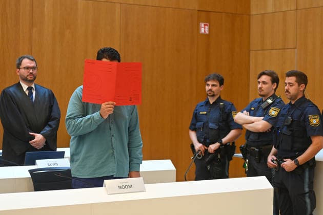 Der Angeklagte im Verhandlungssaal, verbirgt sein Gesicht hinter einem Schnellhefter.Hinten: seinVerteidiger RA Johann BUND. Urteil im Strafverfahren gegen Farhad Noori wegen Mordes u.a.(Seidlstrasse) am 06.08.2026 vor dem Oberlandesgericht Muenchen *** The defendant in the courtroom hides his face behind a binder. Behind him is his defense attorney, Johann BUND. Judgment in the criminal case against Farhad Noori for murder, among other charges, on Seidlstrasse on August 6, 2026, before the Munich Higher Regional Court.