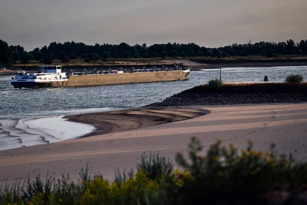 August 6, 2026, Nijmegen, Gelderland, Netherlands: A cargo barge makes its way along the WAAL near NIJMEGEN at sunrise this morning, navigating past exposed sandbanks that reveal just how far the water has dropped. Looking upstream towards GERMANY, this stretch of the WAAL, the main DUTCH branch of the RHINE, shows the impact of prolonged drought, which has reduced river levels to historic lows, forcing inland vessels to sail with sharply reduced loads and raising costs across the supply chain. Credit : ZUMA Press Nijmegen Netherlands - ZUMAv145 20260806_zip_v145_004 Copyright: xNorbertxVoskensx