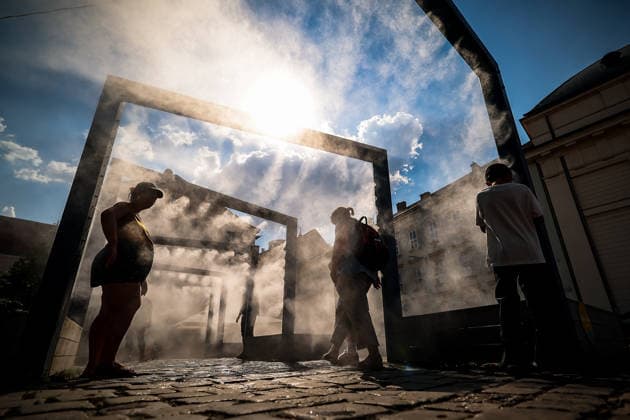 (260806) -- BUDAPEST, Aug. 6, 2026 -- People cool off under a misting system in Budapest, Hungary, Aug. 6, 2026. Hungarian authorities on Tuesday extended the country s highest-level heat alert until midnight on Friday as forecasts indicate the ongoing heatwave will continue across the country. (Photo by h Xinhua) HUNGARY-BUDAPEST-HEAT WAVE DavidxBalog 