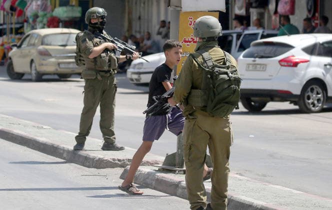 August 6, 2026, Nablus, Palestine: A Palestinian boy walks past Israeli soldiers, during a military operation in neighbourhoods of the Askar refugee camp east of Nablus in the West Bank. The raid is part of a broader military campaign targeting refugee camps in the West Bank. The Israeli government has threatened to occupy refugee camps, in areas under the control of Palestinian President Mahmoud Abbas. Nablus Palestine - ZUMAs197 20260806_aaa_s197_108 Copyright: xNasserxishatyehx