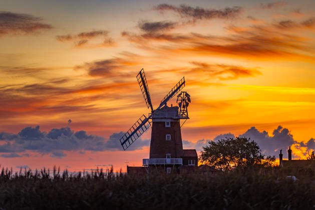 News Bilder des Tages August 7, 2026, Cley Next The Sea, Norfolk, UK: Cley Next The Sea UK. The sky glows orange as the sun starts to rise this morning over Cley windmill in the picturesque village of Cley-Next-The-Sea on the Norfolk coast. Cley Next The Sea UK  - ZUMAl94_ 20260807_zaf_l94_006 Copyright: xAndrewxMccarenx