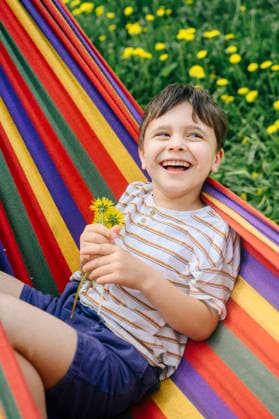 Childhood joy relaxing in a colorful hammock with dandelions model released, Symbolfoto, ANAF06030