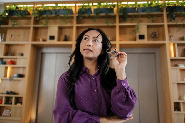 Businesswoman holds eyewear and thinks in a coworking office model released, Symbolfoto property released, ASGF07448