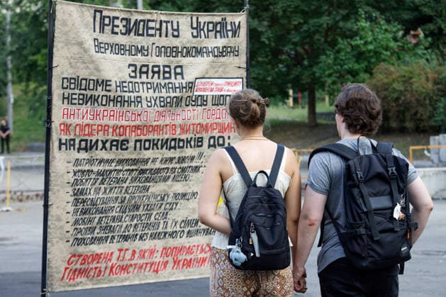 A man and a woman read a text on a placard during a peaceful protest against the dismissal of Mykhailo Fedorov from the post of Ukraine’s Defence Minister in Ivana Franka Square outside the Ivan Franko National Academic Drama Theatre, close to the Office of the President, Kyiv, Ukraine, August 6, 2026. Large-scale cardboard rallies in support of former Defence Minister Mykhailo Fedorov have been held in Kyiv and other cities across Ukraine for 22 consecutive days. On 14 July 2026, the Ukrainian Parliament accepted the resignation of Prime Minister Yuliia Svyrydenko, leading to the resignation of the Cabinet. On 15 July 2026, President Volodymyr Zelenskyy dismissed Defence Minister Mykhailo Fedorov, sparking widespread protests across the  Copyright: xMariannaxKotykx