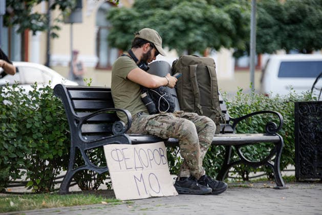 A man in a camouflage uniform sits on a bench near the Fedorov - Defence Minister placard during a peaceful protest against the dismissal of Mykhailo Fedorov from the post of Ukraine’s Defence Minister in Ivana Franka Square outside the Ivan Franko National Academic Drama Theatre, close to the Office of the President, Kyiv, Ukraine, August 6, 2026. Large-scale cardboard rallies in support of former Defence Minister Mykhailo Fedorov have been held in Kyiv and other cities across Ukraine for 22 consecutive days. On 14 July 2026, the Ukrainian Parliament accepted the resignation of Prime Minister Yuliia Svyrydenko, leading to the resignation of the Cabinet. On 15 July 2026, President Volodymyr Zelenskyy dismissed Defence Minister Mykhailo  Copyright: xMariannaxKotykx