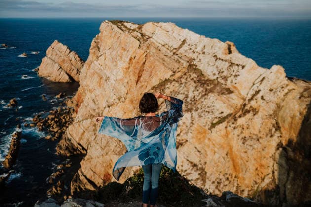 Woman stands on dramatic cliff looking at ocean in Asturias Spain model released, Symbolfoto, GMLF02056