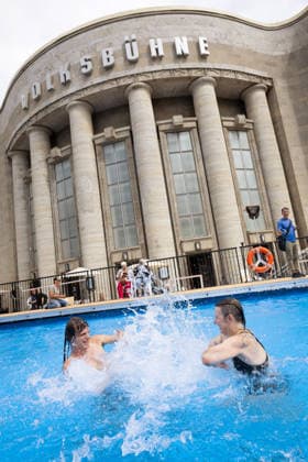Die Volksbuehne hat am 07.08.2026 ein Pop-up-Freibad in Berlin-Mitte eroeffnet (Foto vom 07.08.2026). Das Volksbad ist das erste Projekt des neuen Intendanten Matthias Lilienthal. In dem 25 Meter langen und 1,30 Meter tiefen Becken auf dem Rosa-Luxemburg-Platz koennen Besucher nach Buchung eines Zeitslots kostenlos und ohne Ausweispflicht schwimmen gehen, wie das Theater auf seiner Website angibt. Die fuer acht Wochen geplante Aktion sorgt aber wegen hoher Kosten auch fuer Kritik. (Siehe epd-Meldung vom 07.08.2026) EDITORIAL USE ONLY *** On August 7, 2026, the Volksbühne opened a pop-up outdoor pool in Berlin-Mitte. Photo from August 7, 2026. The Volksbad is the first project of the new artistic director, Matthias Lilienthal. In the 25-me Copyright: epd-bild HansxScherhaufer epd-Pop-up_Volksbad4-kopieren