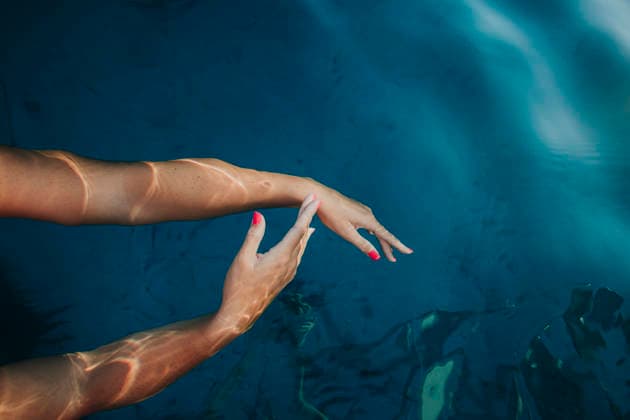 Woman touches the blue sea water from a sailboat in Ibiza model released, Symbolfoto, GMLF02222