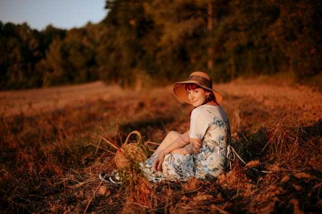 Smiling woman relaxes in a summer field during golden hour model released, Symbolfoto, GMLF02295