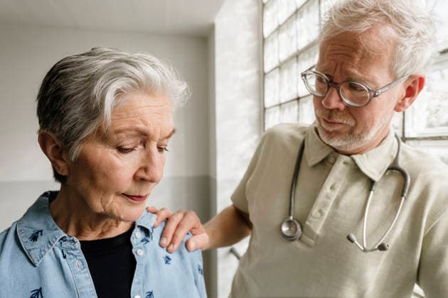 Male doctor comforts female patient after bad diagnosis indoors model released, Symbolfoto property released, KNSF12500