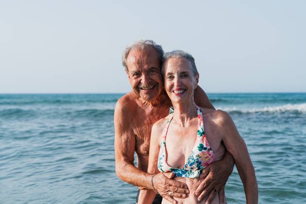 Senior man embraces woman in the ocean during a summer vacation model released, Symbolfoto, MRF02762