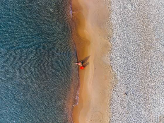 Aerial view of a woman relaxing on a sandy beach by the sea model released, Symbolfoto, MUKF00283