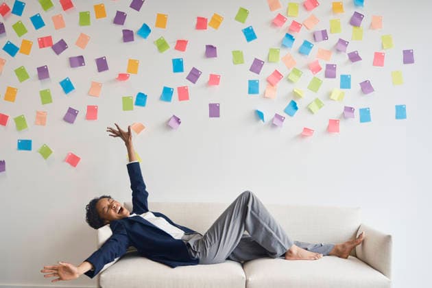 Businesswoman celebrates work success on a couch with sticky notes model released, Symbolfoto property released, PWF01988