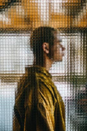 A man stands behind textured glass creating a surreal pixel pattern model released, Symbolfoto property released, YTF04693