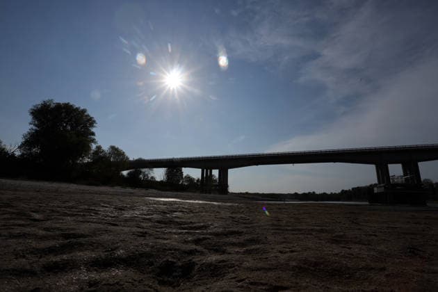 Klima, Dürre : Blick auf das völlig freiliegende Flussbett des Po infolge der schweren Dürre, die die Pianura Padana getroffen hat. An der Pegelstation in Cremona sank der Wasserstand von Italiens längstem Fluss auf einen historischen Tiefststand von mehr als 8,5 Metern unter dem Pegelnullpunkt; der Fluss schrumpfte zu einem Rinnsal, wodurch riesige Sandflächen, auf Grund gelaufene Boote und Unrat zum Vorschein kamen. Die Aufnahmen verdeutlichen die Auswirkungen des Klimawandels auf die lokale Landwirtschaft und das Flussökosystem der Lombardei in Isola Pescaroli , Cremona , Lomabrdei , Italien . August 07 , 2026 . Photo by: Davide Elias IPA Photo Pressefoto DENL Copyright: xDavidexEliasx