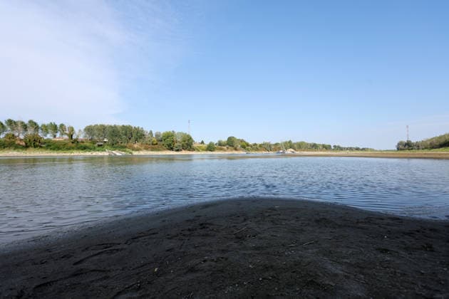 Klima, Dürre : Blick auf das völlig freiliegende Flussbett des Po infolge der schweren Dürre, die die Pianura Padana getroffen hat. An der Pegelstation in Cremona sank der Wasserstand von Italiens längstem Fluss auf einen historischen Tiefststand von mehr als 8,5 Metern unter dem Pegelnullpunkt; der Fluss schrumpfte zu einem Rinnsal, wodurch riesige Sandflächen, auf Grund gelaufene Boote und Unrat zum Vorschein kamen. Die Aufnahmen verdeutlichen die Auswirkungen des Klimawandels auf die lokale Landwirtschaft und das Flussökosystem der Lombardei in Isola Pescaroli , Cremona , Lomabrdei , Italien . August 07 , 2026 . Photo by: Davide Elias IPA Photo Pressefoto DENL Copyright: xDavidexEliasx