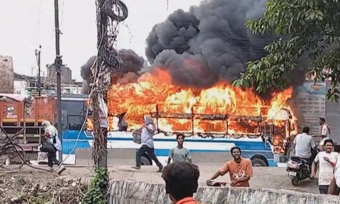 PATNA, INDIA - AUGUST 7: A public transport bus set ablaze by an angry mob after a speeding bus struck and fatally ran over a 22-year-old local resident Manish Kumar along National Highway 30 near the Zero Mile intersection under the Agamkuan police station limits on August 7, 2026 in Patna, India. Incensed by the fatal hit-and-run incident, angry residents and eyewitnesses staged a road blockade, vandalized passing vehicles including public transport bus, three police vehicles, and several two-wheelers. The mob also pelted stones at responding law enforcement teams.(Photo by Santosh Kumar Hindustan Times) Angry Mob Torches Bus, Police Vehicles After Youth Killed by Speeding Bus In Patna