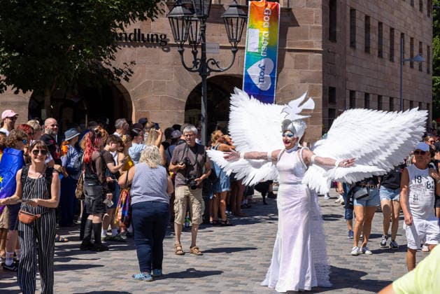 CSD Nürnberg 2026 Nürnberg Pride Week, Nürnberg, 08.08.2026 Beim Christopher Street Day zieht eine Person in weißem Kostüm mit großen Flügeln durch die Innenstadt. Zahlreiche Zuschauer und Teilnehmer säumen die Straße, im Hintergrund ist ein Regenbogen-Banner mit der Aufschrift God bless you zu sehen. Nürnberg Bayern Deutschland *** CSD Nuremberg 2026 Nuremberg Pride Week, Nuremberg, August 8, 2026 During Christopher Street Day, a person in a white costume with large wings parades through the city center. Numerous spectators and participants line the street; in the background, a rainbow banner reading God bless you can be seen. Nuremberg, Bavaria, Germany 20260808-286A4827-M4000