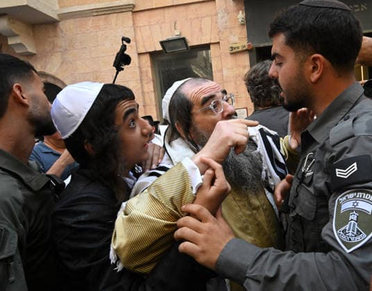 An Israeli border police stops Ultra-Orthodox Jews from reaching Cafe Basimta during a protest against the cafe being open on the Jewish Sabbath, Saturday, in central Jerusalem, August 8, 2026. Few cafes and restaurants are open from dusk on Friday until dusk on Saturday in observance of the Sabbath in Jerusalem.  JER2026080803 DEBBIExHILL