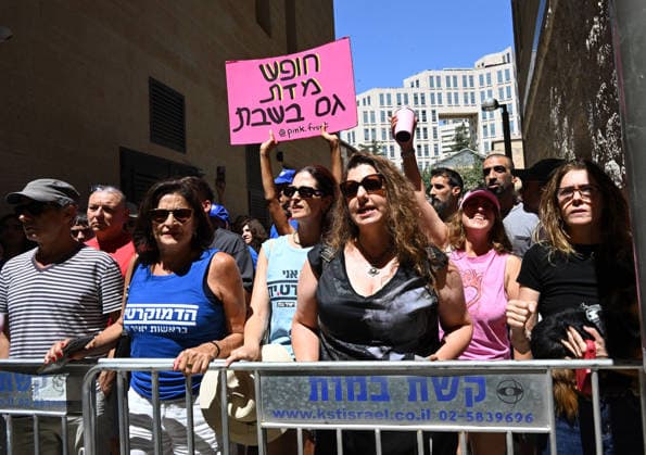 Secular Israelis hold a sign reading in Hebrew Freedom From Religion On Saturday against an Ultra-Orthodox Jewish protest against Cafe Basimta for being open on the Jewish Sabbath, Saturday, in central Jerusalem, August 8, 2026. Few cafes and restaurants are open from dusk on Friday until dusk on Saturday in observance of the Sabbath in Jerusalem.  JER2026080808 DEBBIExHILL