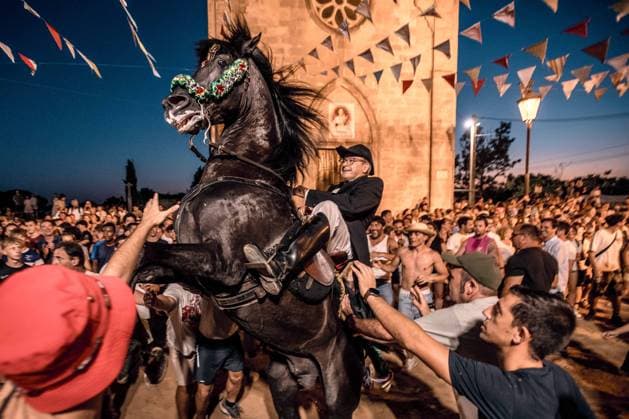 August 8, 2026, Llucmacanes, Menorca Balearic Islands, Spain: A caixer, or horse rider, rears his horse amid a cheering crowd during the traditional Jaleo at the Sant Gaieta Festival in Llucmacanes Llucmacanes Spain - ZUMAo105 20260808_fap_o105_009 Copyright: xMatthiasxOesterlex