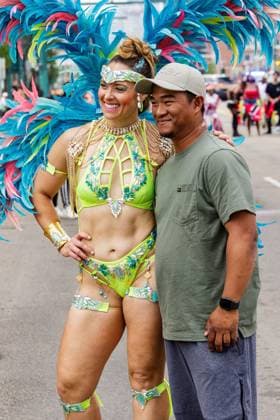 August 8, 2026, Edmonton, Alberta, Canada: Mas Band members stop to pose with parade watchers in downtown Edmonton during the Cariwest Parade on day 2 of the Cariwest Festival..Western Canada s largest Caribbean Festival, Cariwest, held its annual parade as part of its 42nd year of festivities. The Parade Mas Bands represent the various Caribbean various Islands and are dressed in brightly colored costumes, some of which can weigh up to 200 lbs, requiring wheels to support the weight. Edmonton Canada - ZUMAs197 20260808_aaa_s197_236 Copyright: xRonxPalmerx