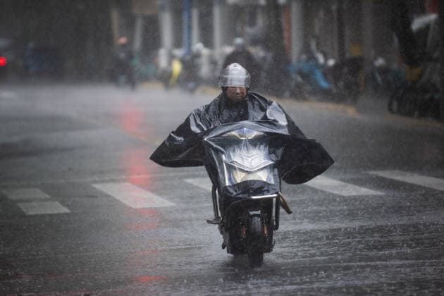 SHANGHAI, CHINA - AUGUST 09: A resident rides an electric bicycle in the rain on August 9, 2026 in Shanghai, China. The city Shanghai is experiencing heavy rain and strong winds due to the impact of Typhoon Dolphin.  Copyright: xVCGx 111658938186