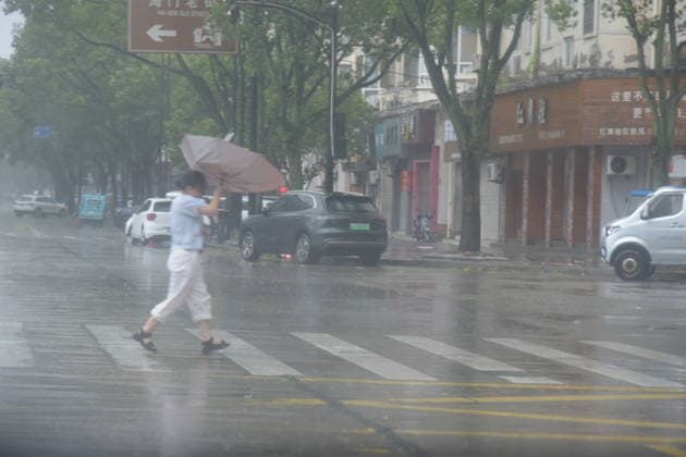 TAIZHOU, CHINA - AUGUST 09: Pedestrians walk through strong winds on Zhongshan East Road as Typhoon Dolphin approaches on August 9, 2026 in Taizhou, Zhejiang Province of China. Typhoon Nongfa is expected to make landfall soon, bringing heavy rain and gale-force winds to the coastal region.  Copyright: xVCGx 111658959963