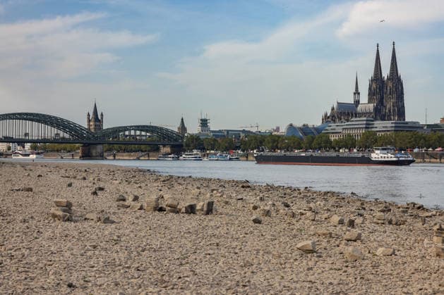 Sommer im Rheinland. Blick auf den Rhein bei Koeln (Köln) - Deutz. Der Rhein in Koeln (Köln) fuehrt (führt) Niedrigwasser aufgrund anhaltender Trockenheit. Im Hintergrund die Hohenzollernbruecke (Hohenzollernbrücke) (links) und der Koelner (Kölner) Dom (rechts). Ein Schiff ist unterwegs. Sommer im Rheinland am 09.08.2026 in Koeln (Köln) Deutschland. *** Summer in the Rhineland: View of the Rhine near Cologne (Deutz). The Rhine in Cologne is at low water levels due to persistent drought. In the background, the Hohenzollern Bridge is on the left and Cologne Cathedral is on the right. A ship is passing by. Summer in the Rhineland on August 9, 2026 in Cologne, Germany