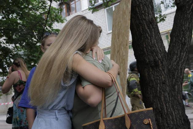 Russian Drone Strike On Residential Building - Kharkiv A woman embraces a child near a tree as residents gather in a courtyard following drone strikes on multi-story residential buildings in Kharkiv s Saltivka district, Ukraine, on August 9, 2026. The strikes destroyed several floors of at least two high-rise buildings, killing two people and wounding 27 others, according to Kharkiv Mayor Ihor Terekhov and regional officials. Photo by Yevhen Titov ABACAPRESS.COM Kharkiv Kharkiv Oblast Ukraine  Copyright: xTitovxYevhen ABACAx