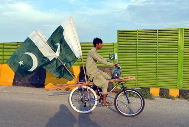 August 9, 2026, Pakistan: Boy Prepares for 79th Independence Day of Pakistan with Flags and Bamboo Sticks on GT Road in Peshawar Pakistan  - ZUMAas3_ 20260809_zaf_as3_008 Copyright: xPPIx