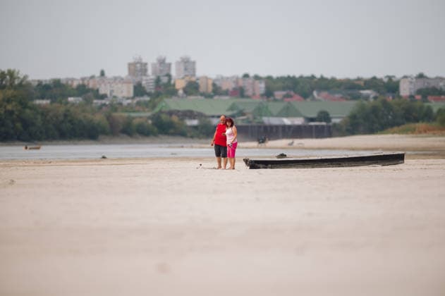 Hungarian nuclear power plant Paks runs on minimum due to water shortage PAKS, HUNGARY - AUGUST 9: A couple stands next to a stranded dinghy on the dry river bed of the Danube near the Paks Nuclear Power Plant in Paks, Hungary on August 9, 2026. The plant is currently operating with only one of its four reactors at minimum output, an unprecedented situation in its nearly 40-year history, as historically low Danube water levels caused by severe drought have constrained the plant’s cooling capacity. ( Robert Nemeti - Anadolu Agency ) Hungary Hungary. Editorial use only. Please get in touch for any other usage.  Copyright: xAnadoluxAgencyxx