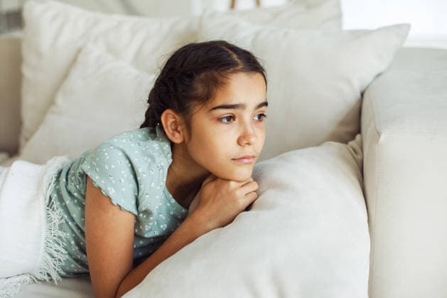 Ein zehnjähriges Mädchen mit Zöpfen liegt auf dem Sofa A ten-year-old girl with pigtails is lying on the sofa, she wants to sleep. (License=RF) ,model released, Symbolfoto Copyright: xZoonar.com RaisaxKanarevax 25378241 ,model released, Symbolfoto ,property released